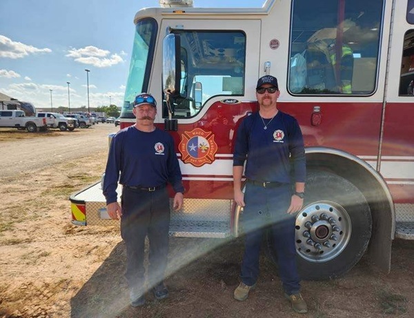 Two firefighters standing in front of a Waco fire engine in Kerrville