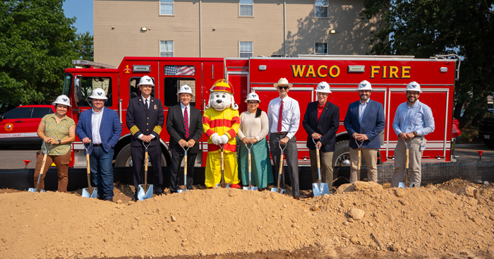 City officials and Sparky the Fire Dog holding shovels at the Fire Station 4 construction site