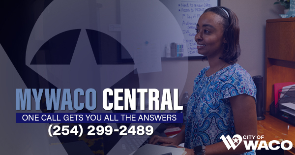 A black woman looking at a computer monitor in her office