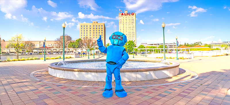 Blue futuristic robot mascot in downtown Waco. ALICO building in the background.