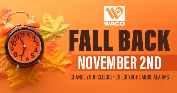 An alarm clock sitting on a small pile of leaves