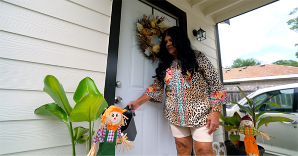 Carol Salcedo watering her plants outside her newly remodeled home