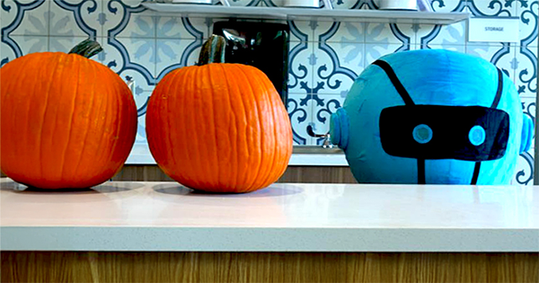 Captain Atom next to two round pumpkins