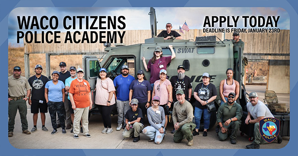 A group of people standing in front of a SWAT truck