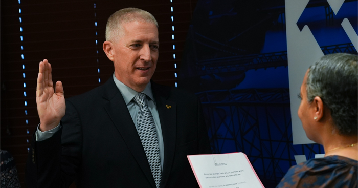Ryan Holt holding up his right hand for swearing in oath