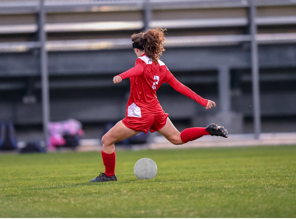 Action shot of a Woodlands resident playing competitive soccer on a local field