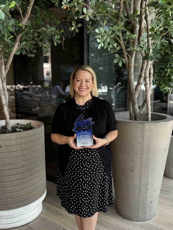 Communications project manager Kacie Gurney poses with the 2024 Savvy Award at the 3CMA Conference in Arlington, TX.