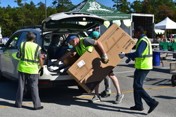 man taking a cardboard box out of a car