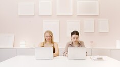 Two women sitting at laptops