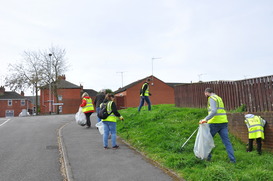 A group of people wearing high-visibility vests litter-picking at Sandy Lane, Worksop.