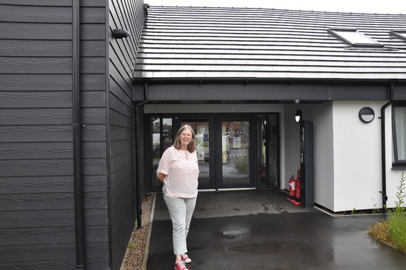 Cllr Lynne Schuller outside the entrance to Westmorland House