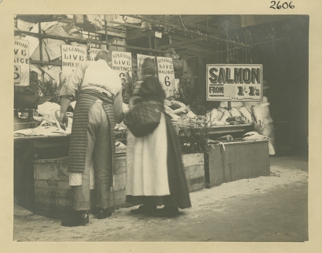 Bromide print showing an interior view of a market trader with a customer at fish stall, in the  Market Hall, Birmingham in 1901.