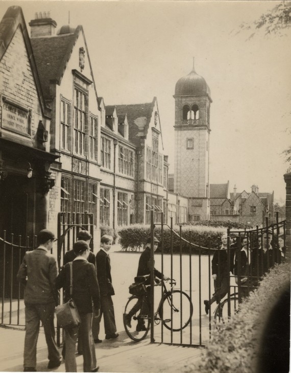 Black & white photo of George Dixon School, Edgbaston, showing schoolboys walking to school through the gates of the playground.