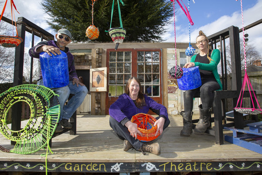 Three members of Allens Cross Community Garden on a community stage