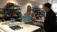 Melanie and Michael look at fabrics on a cutting table
