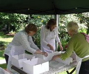 Woman crowded around table sorting cakes out