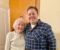 Older lady and younger gentleman smiling for the camera