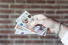 Woman holding some £10 notes