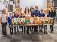 Children holding a banner of their winning paintings