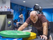 Man pushing boxes and weight at a gym