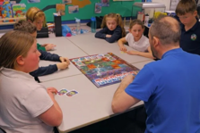 man playing a board game with a group of children