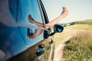 Coffee cup being held out of a car window