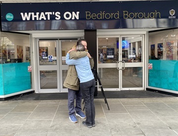 Two people hugging outside the Visitor Information Centre on Silver Street