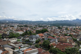 The Indonesian city of Badung, as viewed from on-high. There is a mountain range in the background.