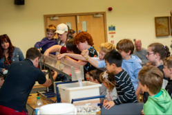 Children getting close to a geology demonstration 