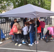 Families look at mineral specimens under a gazeebo outside the Royal Society.