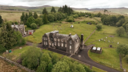 Eskdalemuir in the Scottish borders. It is a large, grey manor house with scientific equipment on the lawns to the back of the house.