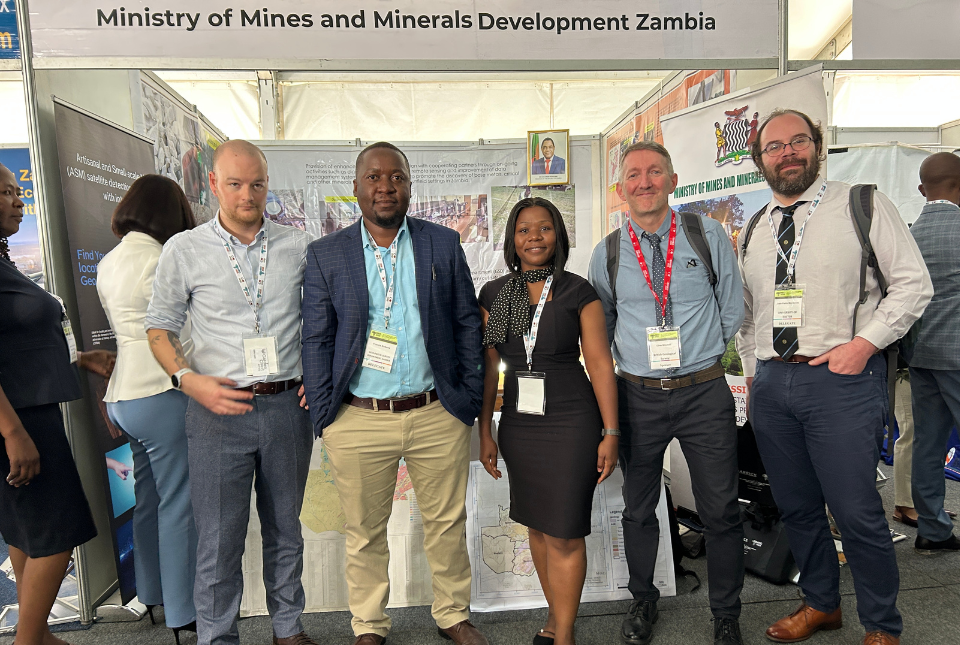 BGS and Ministry of Mines and Minerals colleagues at a conference together. They stand in a row, looking to calendar.