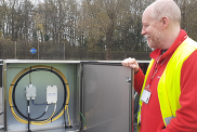 Dr Adam Booth inspecting a short section of fibre-optic cable. © Fleur Loveridge, University of Leeds.