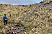 BGS Marine Geoscientist Duncan Stevens observing the glacial till exposure at the Black Burn site, Auchencorth Moss. 