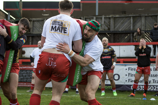 Photo of rugby players wearing shirts with slogan on reverse - Check in with your mate