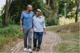 Photo of a man walking with his dad with an arm around his shoulder