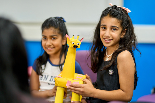 Les Giraffes junk model picture of 2 girls holding their giraffe model
