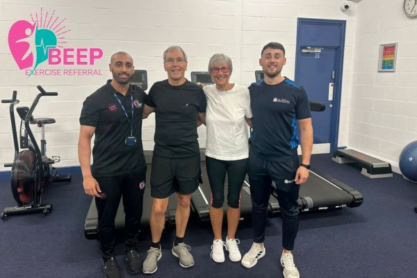 Photo of Jacqueline and Philip Tedder with BEEP referral officers in a gym smiling into camera