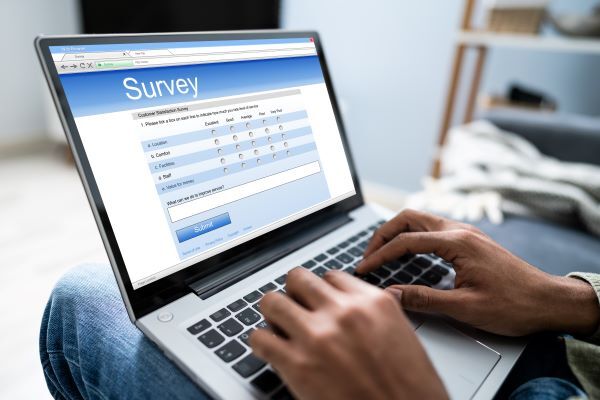 Photograph of someone completing a survey on a laptop