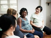 Photo of pregnant women sitting together talking