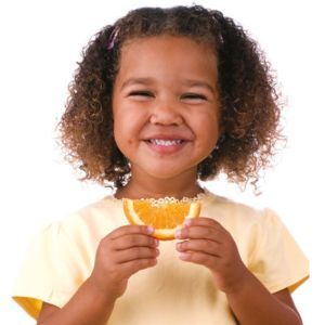 Photo of young girl eating an orange slice