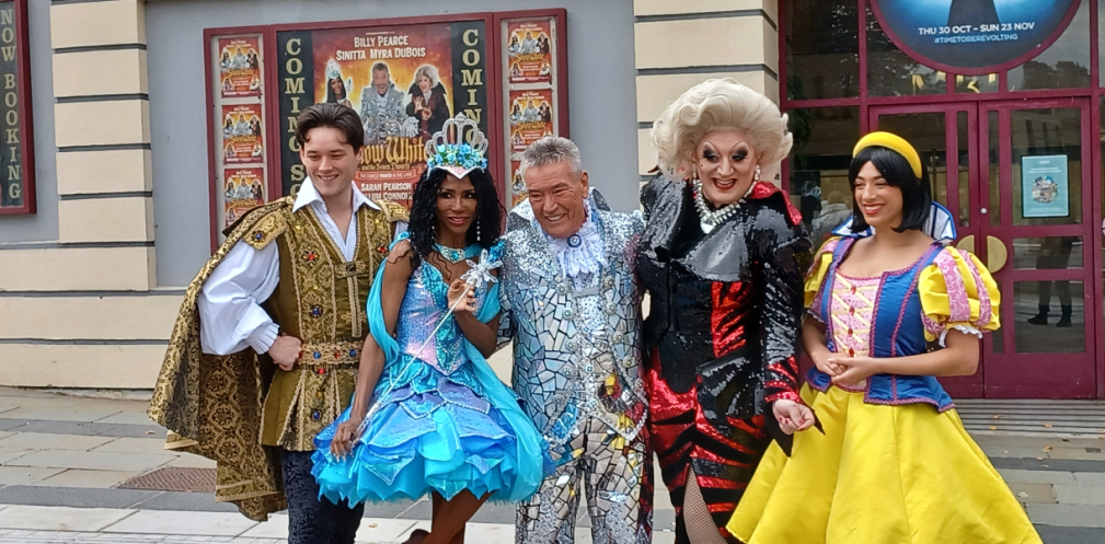 A theatrical cast posing