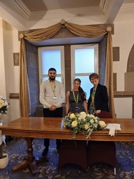 Three people stood at a desk