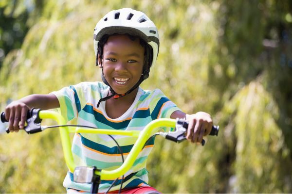 Photo of a child smiling riding his bike