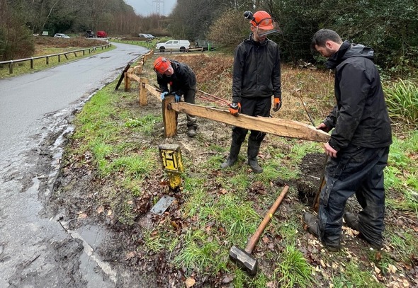 Three rangers constructing a wooden fence at Wildmoor Heath