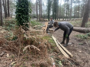 Two Bracknell Forest Council rangers crafting wood in a woodland