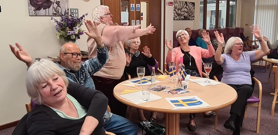 Residents sat round a table singing