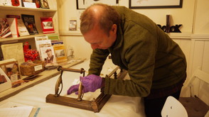 volunteer inspecting items at the museum