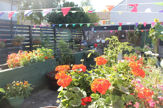 planters with orange flowers in. Bunting overhead