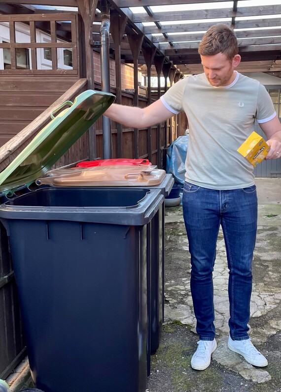 Resident opening green lidded bin